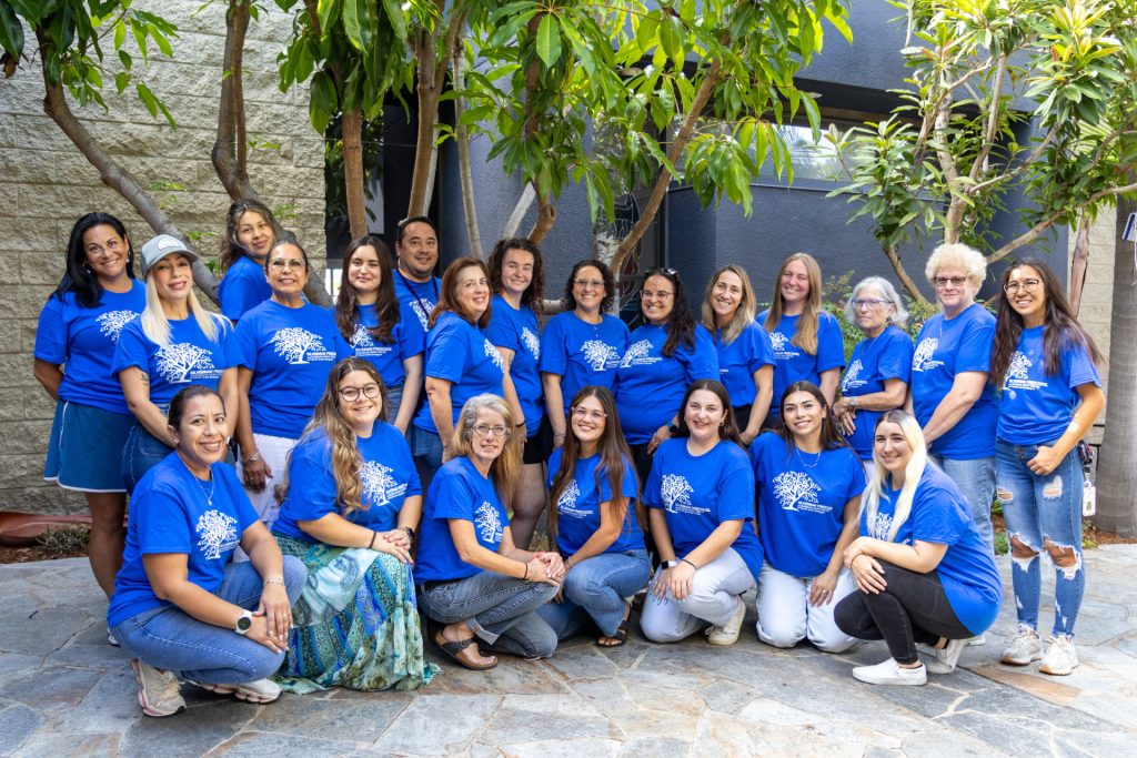 Silverman Preschool teachers pose together for a group photo in matching blue shirts.