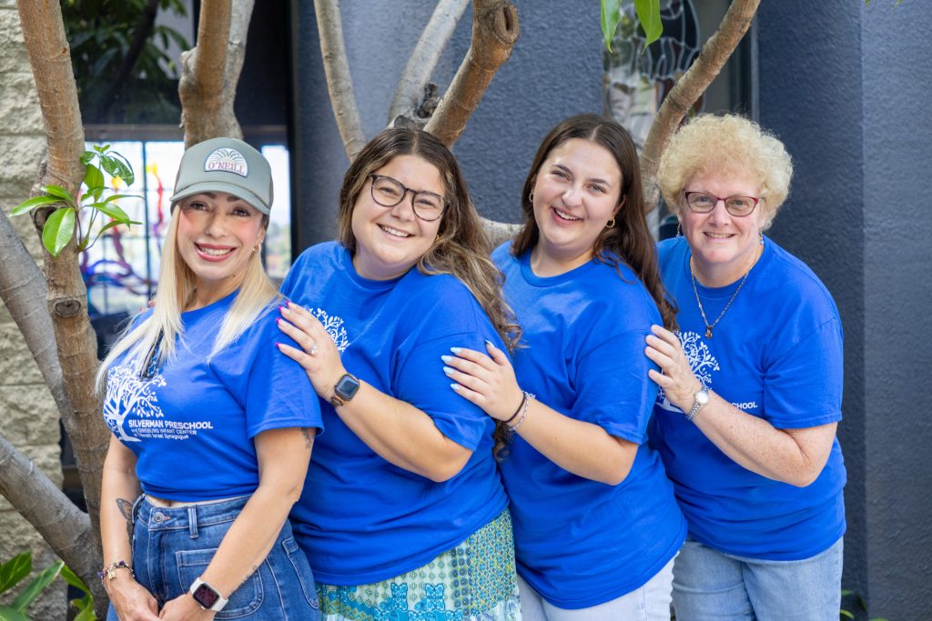Silverman Preschool teachers for the 3 and 4 year old classes pose together for a group photo in matching blue shirts.