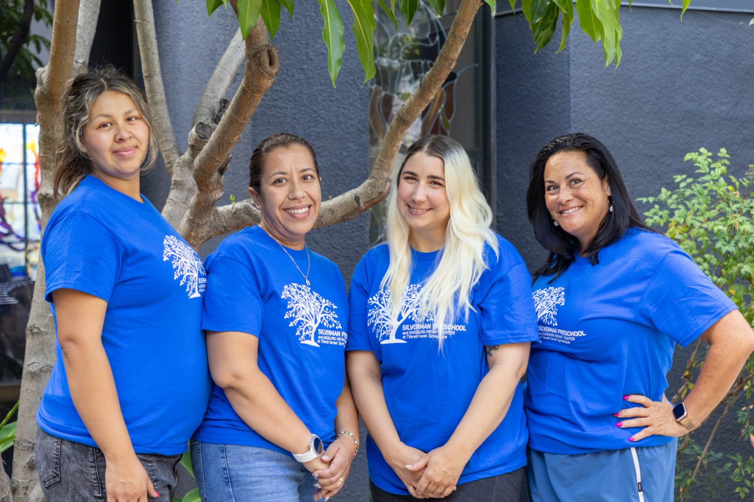 Silverman Preschool Infant teachers pose together for a group photo in matching blue shirts.