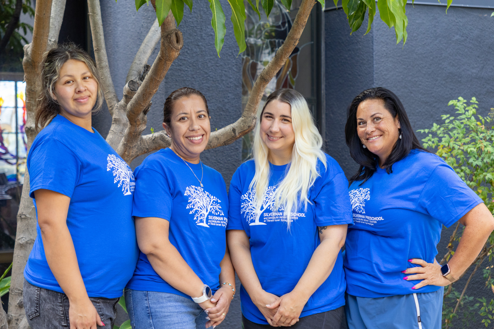 Silverman Preschool Infant teachers pose together for a group photo in matching blue shirts.