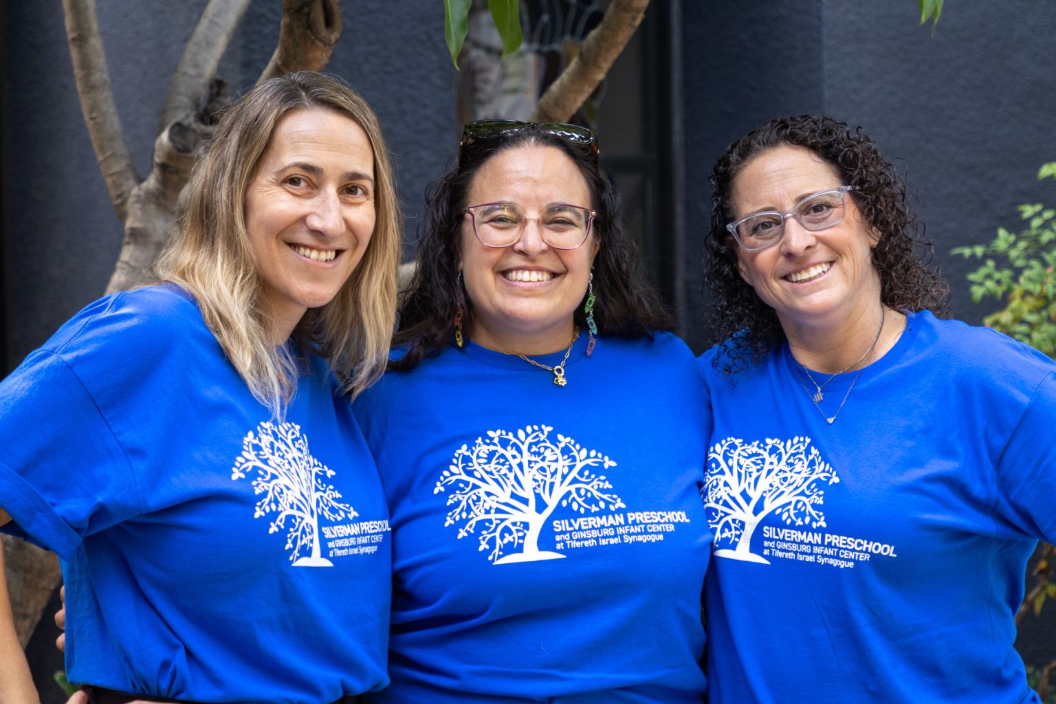 Silverman Preschool Admin Team pose together for a group photo in matching blue shirts.