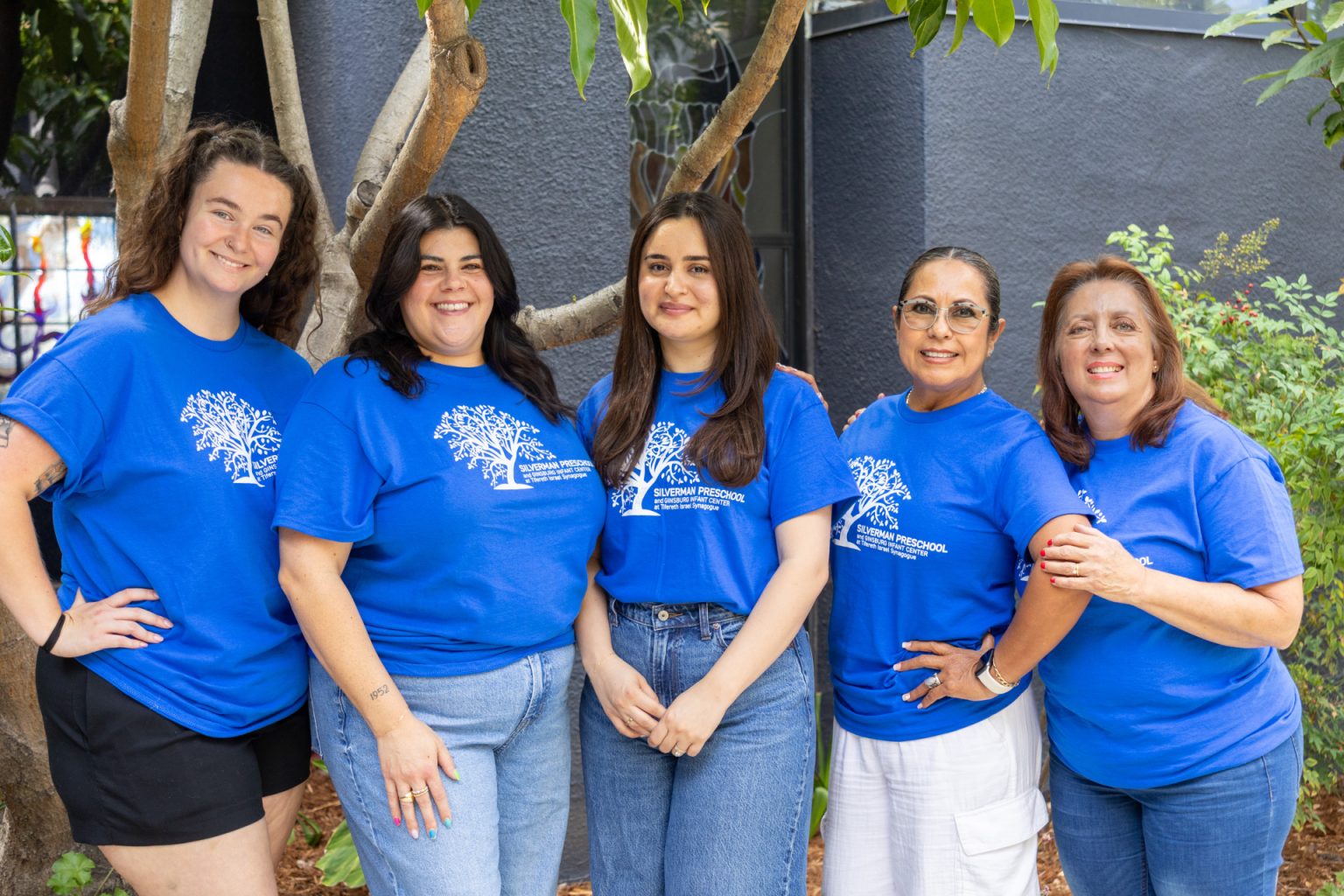 Silverman Preschool Toddler teachers pose together for a group photo in matching blue shirts.
