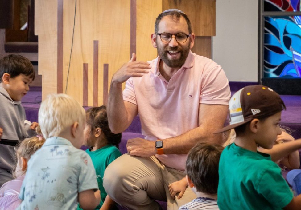 Rabbi Hanan singing with preschool students.